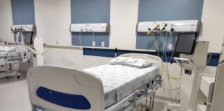 cama de hospital arrumada com equipamentos ao lado