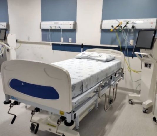 cama de hospital arrumada com equipamentos ao lado