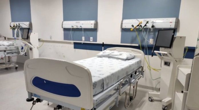 cama de hospital arrumada com equipamentos ao lado