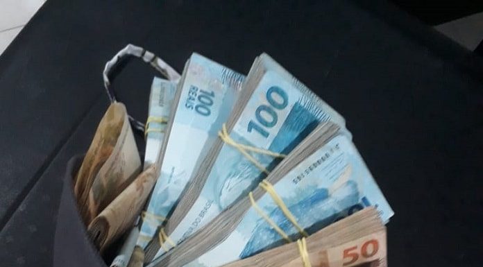 maços de dinheiro parcialmente dentro de uma bolsa