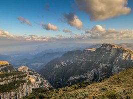 morro da pedra furada com montanhas em volta e vale ao fundo, nuvens no ceu