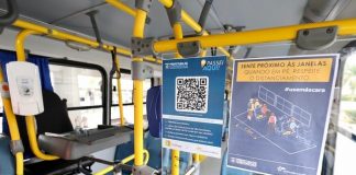 placa com qr code ao lado de catraca dentro de ônibus