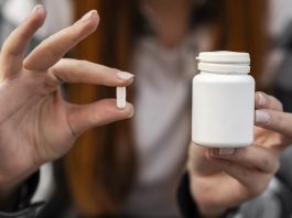 Remédios do SUS roubados em Palhoça para revenda são recuperados mulher segura pílula com dois dedos em uma mão e na outra o pote de remédio