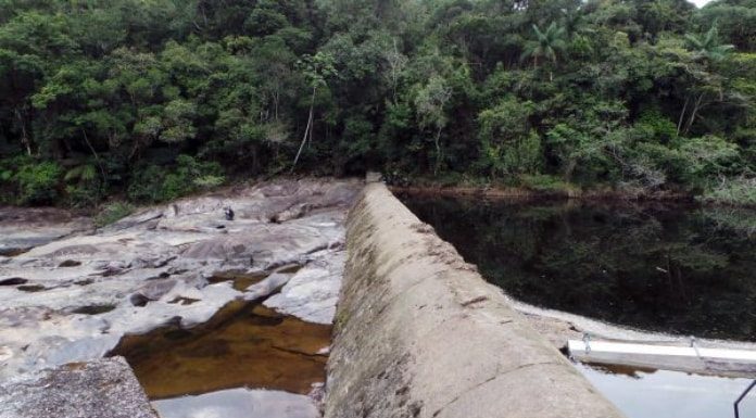muro de contenção da captação de água do rio pilões, com margem do outro lado ao fundo da foto repleta de árvores