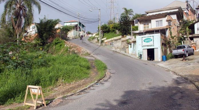 trecho em duas cuvas mais íngremes da rua com moto no alto e casas em volta