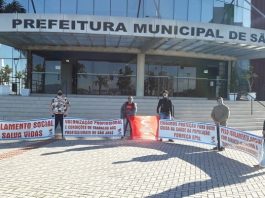 cinco pessoas seguram faixas uma em cada ponta em frente à prefeitura de são josé com mensagens de apoio ao isolamento social