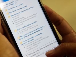pessoas segurando celular em que está aberto aplicativo da caixaq