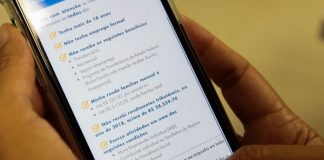 pessoas segurando celular em que está aberto aplicativo da caixaq