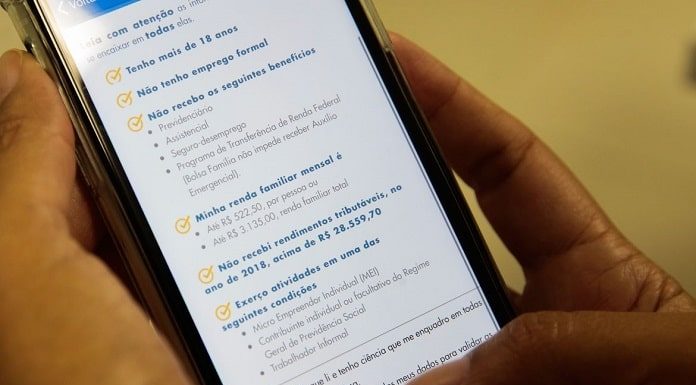 pessoas segurando celular em que está aberto aplicativo da caixaq