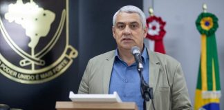 vereador josé simas discusando em tribuna com bandeiras ao fundo