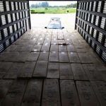 foto de dentro do baú do caminhão sobre todas as caixas de cigarros gift organizadas; ao fundo baú aberto e viatura lá fora