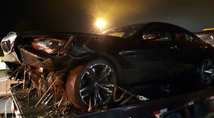 bmw com a frente destruída sobre o guincho