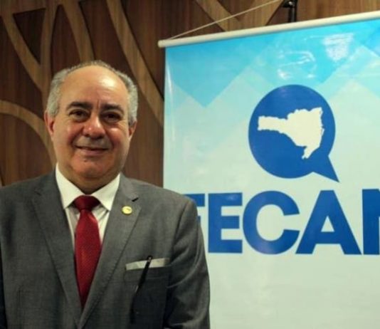Após prisão, Orildo Severgnini renúncia à presidência da Fecam orildo sorridente para a foto ao lao de banner da fecam