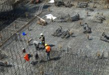 operários em grande local com piso de barras de ferro para ser concretado