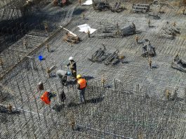 operários em grande local com piso de barras de ferro para ser concretado