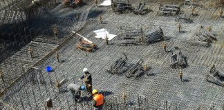 operários em grande local com piso de barras de ferro para ser concretado