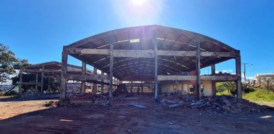 estrutura de concreto de ginásio parcialmente demolida em grande terreno