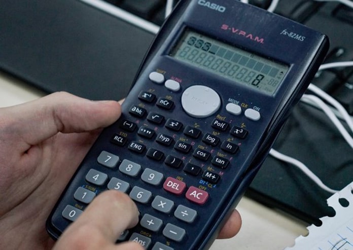 mão segurando uma calculadora