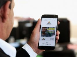 Jucesc lança nova ferramenta de comunicação nessa segunda-feira homem olha para tela de celular com site da jucesc aberto