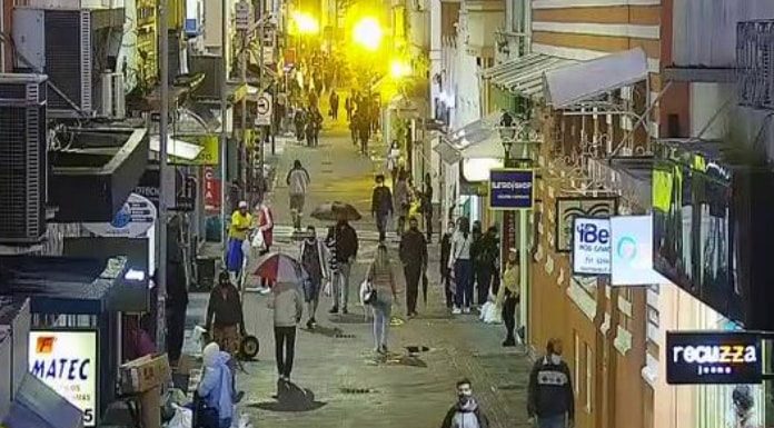 pessoas andando no centro de florianópolis vistas de cima e de longe, usam máscaras e foto noturna