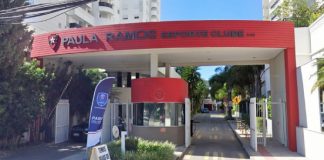 entrada do clube com pórtico sobre guarita e entrada de veículos