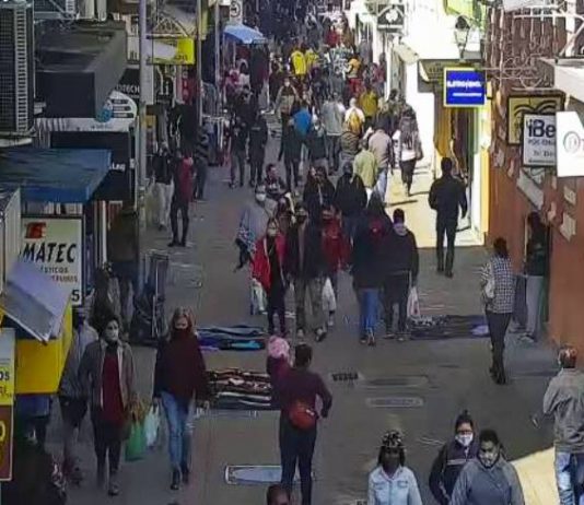 pessoas andando de mascaras e roupas de frio no calcadao da rua conselheiro mafra centro florianopolis