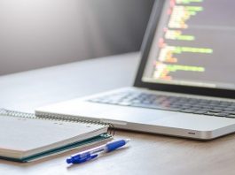 UFSC sofre ataque de hackers no primeiro dia de aulas online caderno e caneta em frente a um notebook com códigos na tela