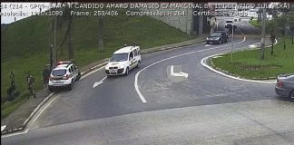 imagem de câmera de segurança do trevo de barreiros onde há viatura da pm sobre calçada, com policias e outros homens ao lado; carro passando