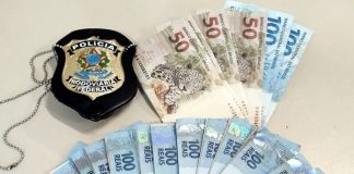 Dinheiro falso e distintivo da polícia em cima de uma mesa