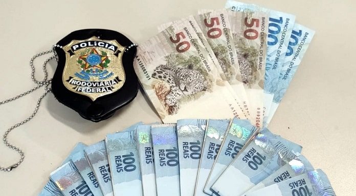 Dinheiro falso e distintivo da polícia em cima de uma mesa