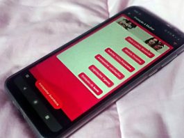 aplicativo pmsc aberto na tela de celular sobre cama; tela mostra sessão de proteção à mulher