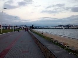 calçadão da av. beira-mar de são josé em dia nublado e ventoso, com pessoas ao longe