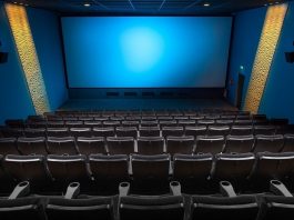 sala de cinema vista do alto com todas as cadeiras vazias e tela azul ao fundo - cinemas reabrem