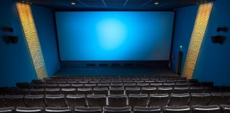sala de cinema vista do alto com todas as cadeiras vazias e tela azul ao fundo - cinemas reabrem