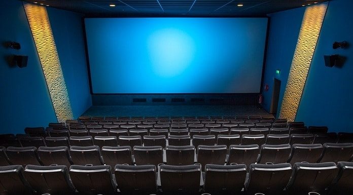 sala de cinema vista do alto com todas as cadeiras vazias e tela azul ao fundo - cinemas reabrem