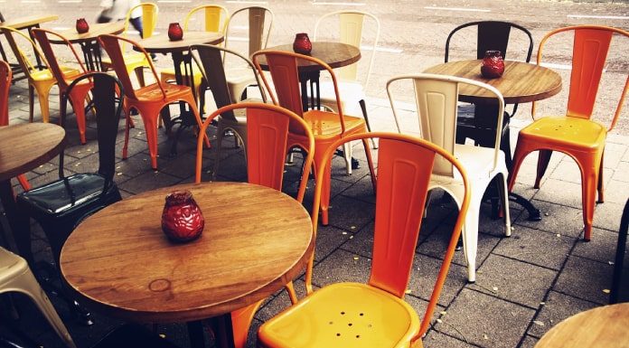 mesas e cadeiras organizadas em calçada