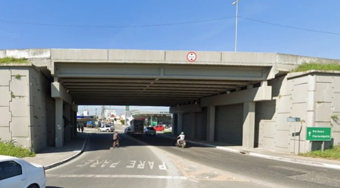 tunel sob a rodovia br 101 com carro passando e moto