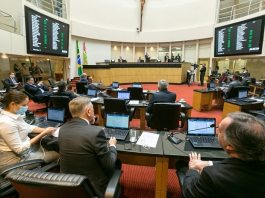 homens sentados naplenário da câmara dos deputados com computadores a frente