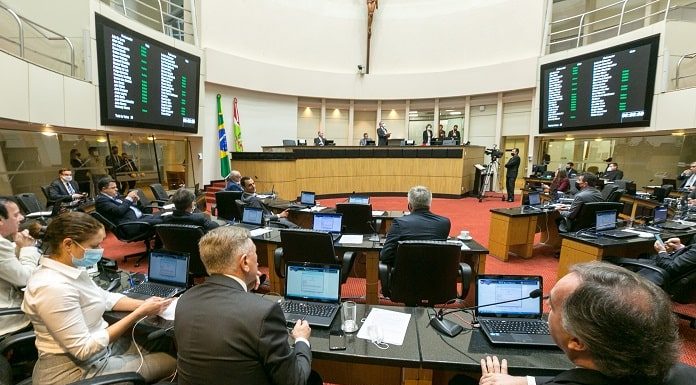 homens sentados naplenário da câmara dos deputados com computadores a frente