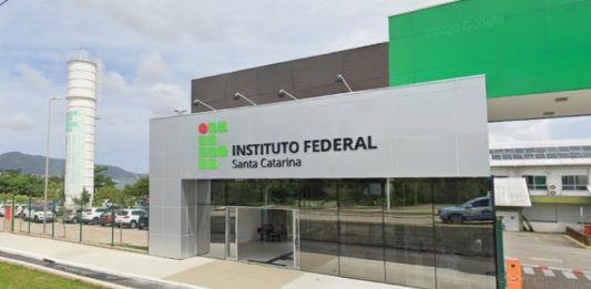 IFSC: fachada do instituto federal de santa catarina com inscrição do nome no campus de coqueiros; torre de caixa d'água ao fundo