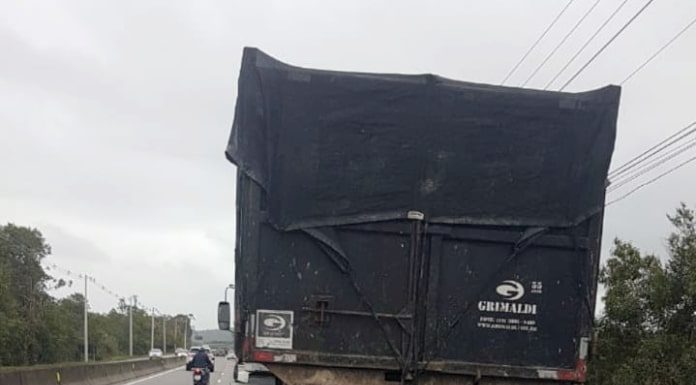 moto caída atrás do caminhão, parados na pista direita e com cones em volta