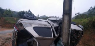 carro tombado de lado com teto batido em poste, destruído