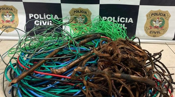 bolo de cabos elétricos de diversas cores, alguns desencapados, em chão da delegacia