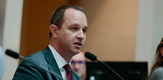 jorge tasca usa terno e fala ao microfone