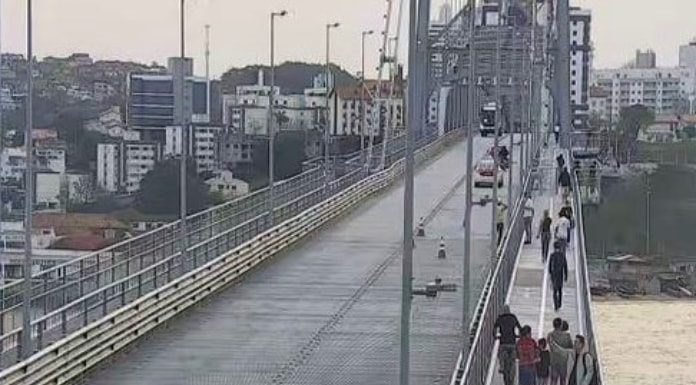 videomonitoramento da ponte mostra pessoas andando em passarela à direita e carro ao fundo no meio da ponte; continente do outro lado