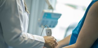 médica faz exame de ultrassom no braço de uma paciente
