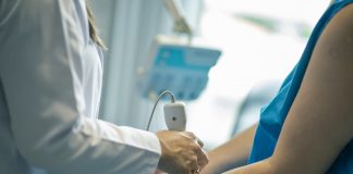 médica faz exame de ultrassom no braço de uma paciente