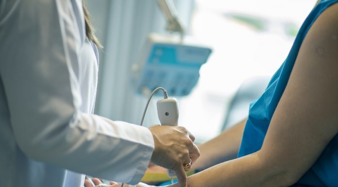 médica faz exame de ultrassom no braço de uma paciente