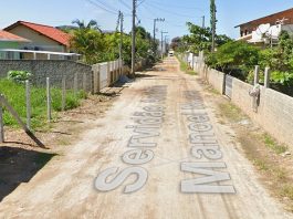 Mulher de 24 anos: imagem da servidão com rua de terra e nome da servidão escrito por cima; casas em volta