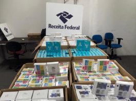 dezenas de caixas de fones de ouvido dentro de caixas de papelão com grande placa da receita federal por cima